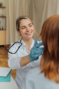 A cheerful healthcare professional examining a patient indoors, promoting positive healthcare experiences.