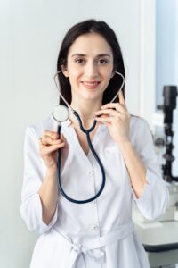 Portrait of a smiling female doctor holding a stethoscope, showcasing professionalism in a healthcare setting.